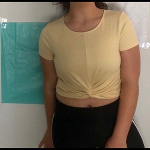 Yellow crop top with a not at the end of the shirt